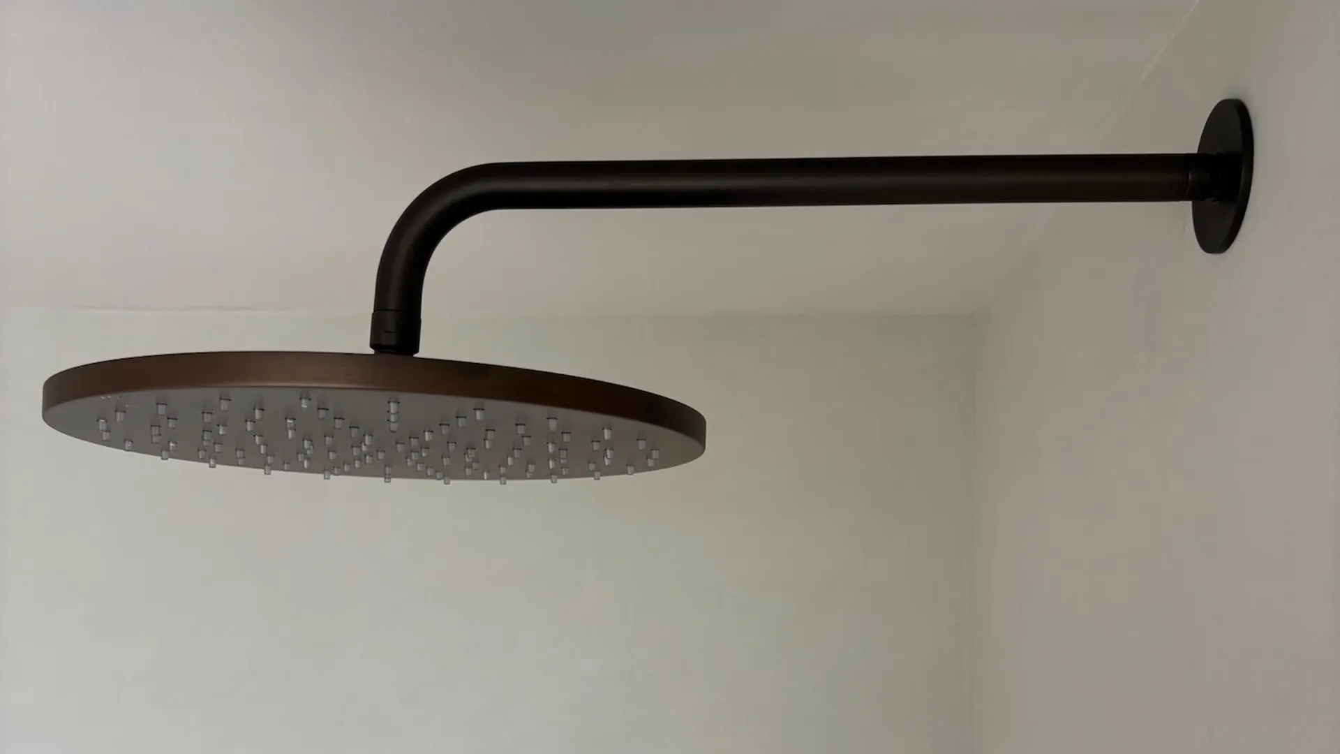 Naadloze douche in FORCRETE microcement met zwarte regendouche
