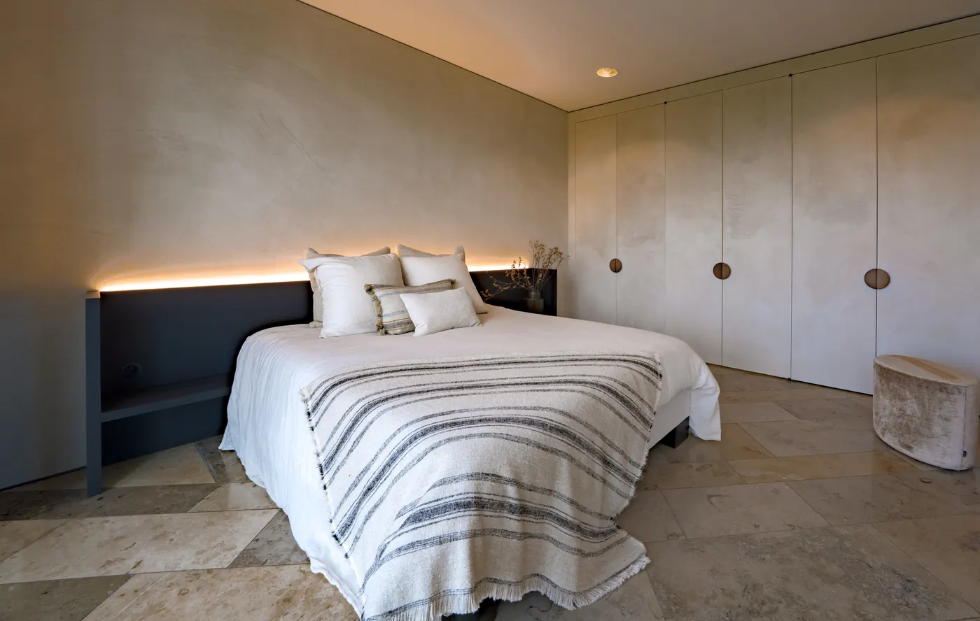Slaapkamer met naadloos afgewerkte wanden en indirect licht — showroom Luxhome